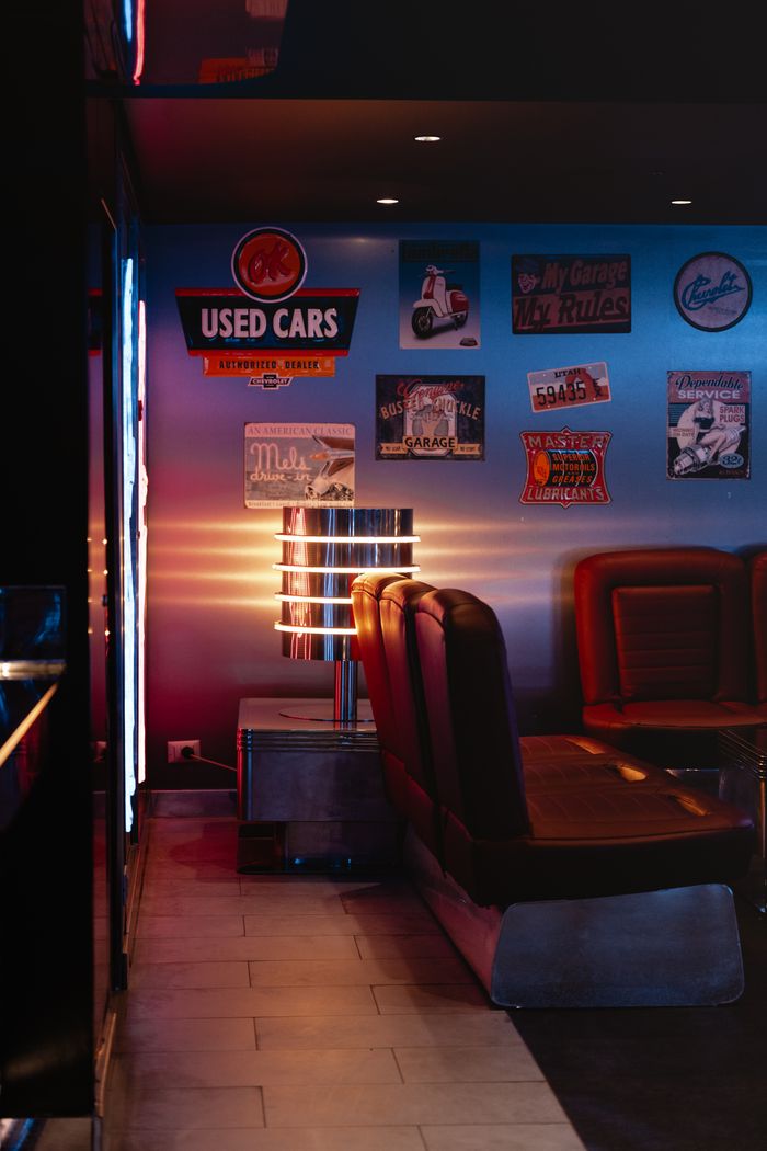 Cozy retro diner interior with vintage decor and leather booths under warm lighting.